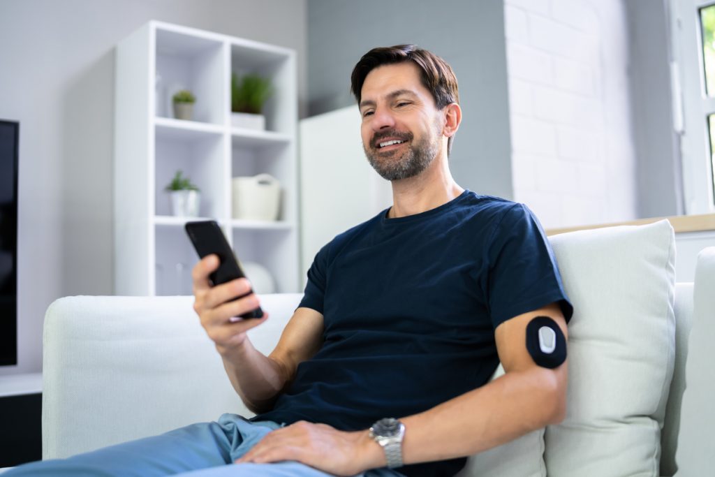 Man Using Continuous Glucose Remote Monitor Diabetes Sensor