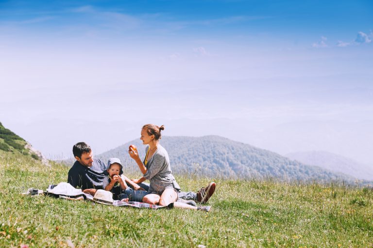 Beautiful happy family spends time on nature in the mountains. Family background. Lifestyle, Travel concept. Parent and child together. Velika Planina or Big Pasture Plateau in the Kamnik Alps, Slovenia